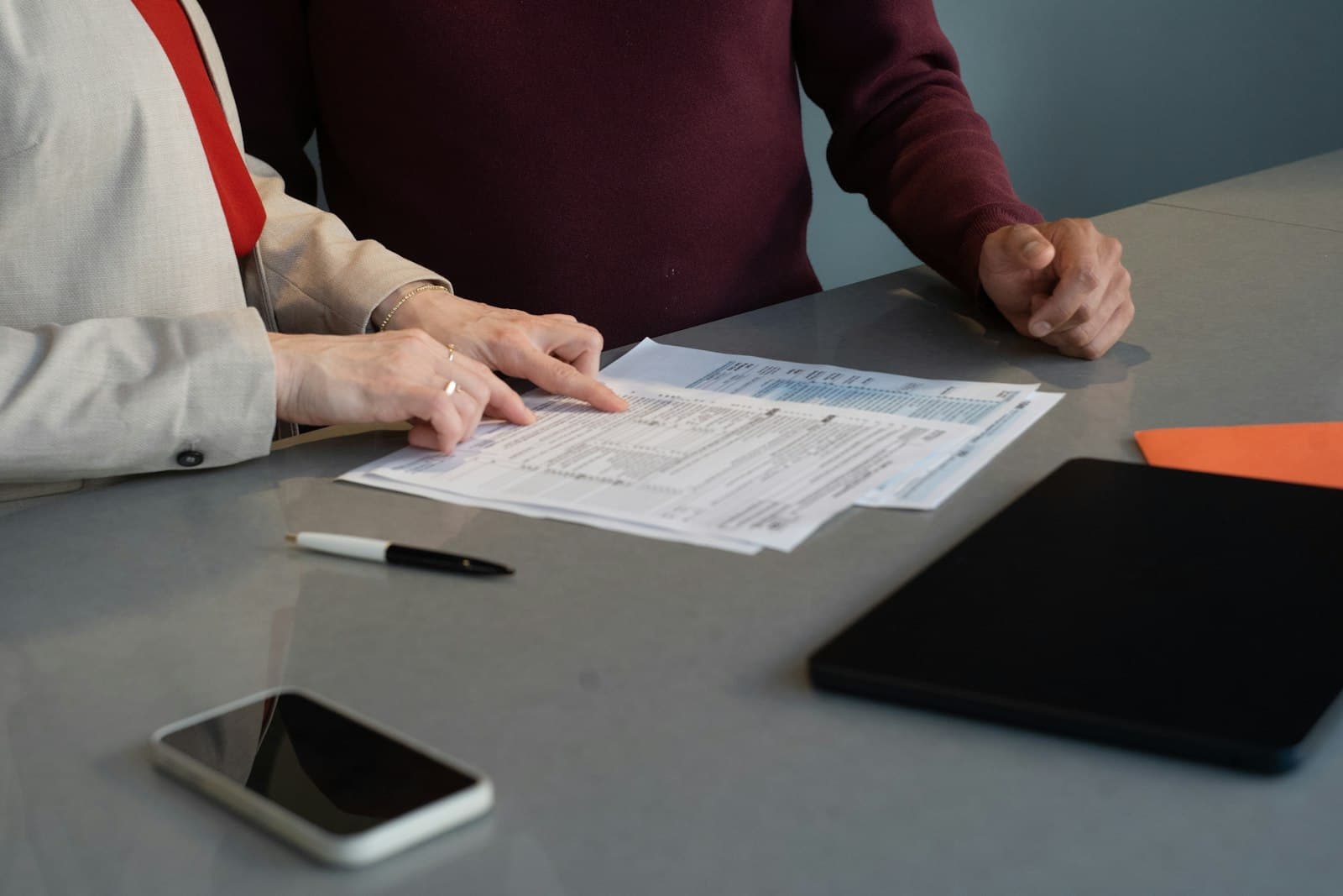 Two business professionals reviewing funding paperwork together across a desk